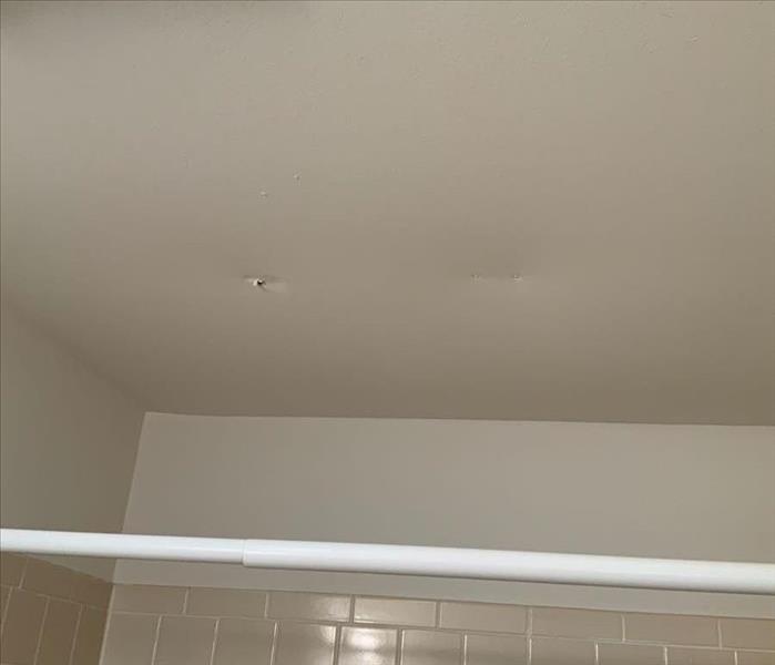 Bathroom ceiling with two discolored spots in the ceiling