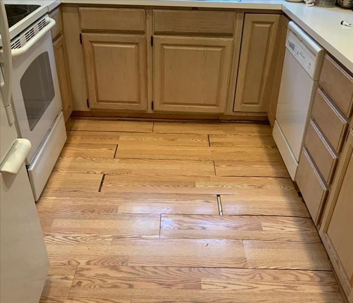 Kitchen with damaged wood floorboards