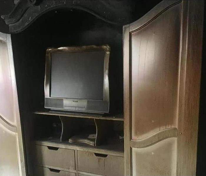 A TV stand with fire damage. 