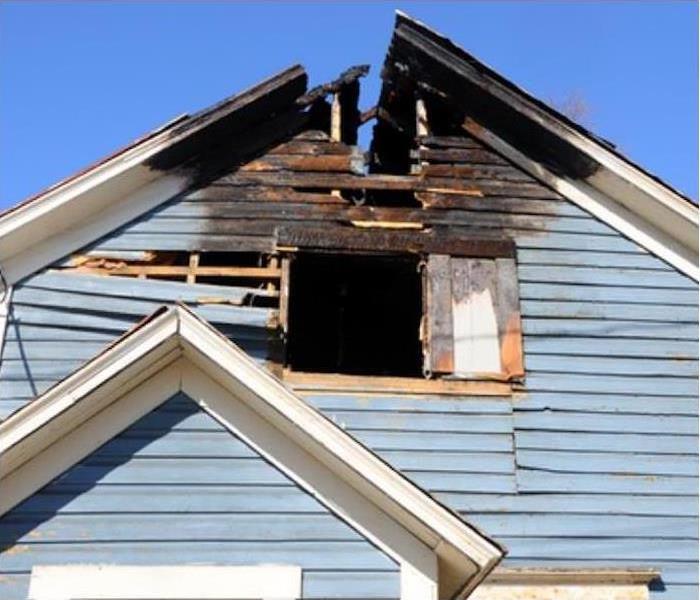 Fire damage to the top point of the outside roof of a home. 